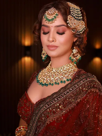 A close-up on the eye makeup and hair. The soft curls and defined eyes perfectly complement the heavy traditional jewelry.