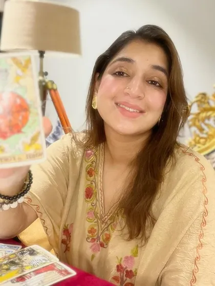Holding the Ace of Cups, a card of new emotional beginnings, love, and intuition. My tarot readings are not just about predictions, they are about understanding the emotional currents in your life and opening your heart to new possibilities.