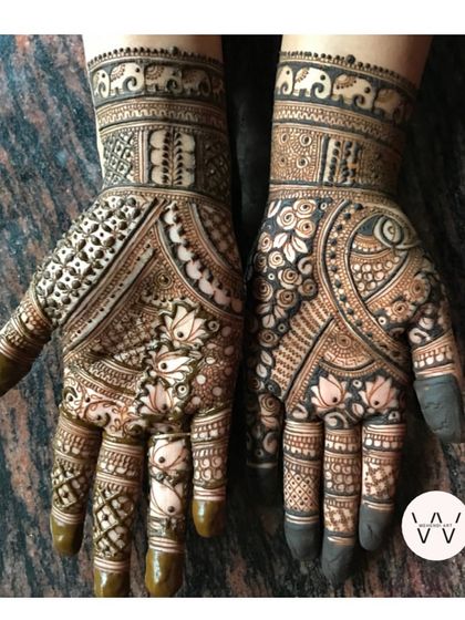 A creative and beautiful design for Teej, with one hand featuring geometric patterns and the other with flowing floral work.