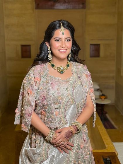 A smiling portrait that shows off her beautiful emerald jewelry and the fresh, dewy finish of her skin.