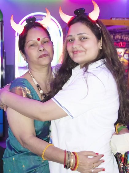 Two women sharing a hug at a party. I capture the fun and candid moments between guests.