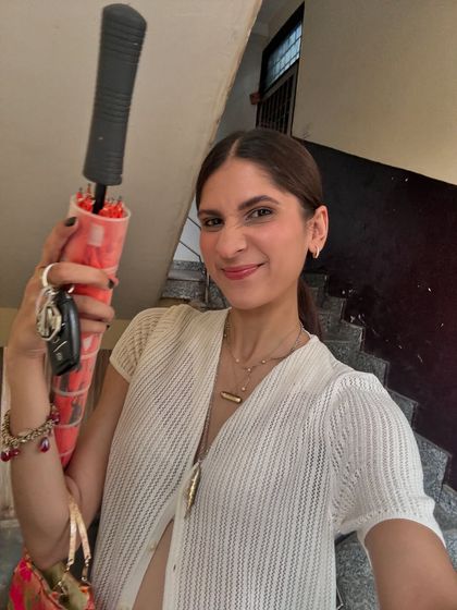 A candid, happy selfie showing a typical "running errands" look. A lightweight knit cardigan, layered necklaces, and a fun bag are my essentials.