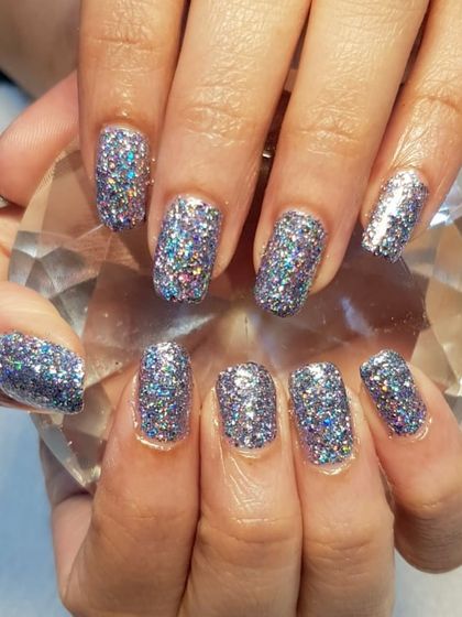 Ready for the festive season with these dazzling glitter nails. This look features full-coverage holographic silver glitter for a manicure that is sure to be the life of the party.