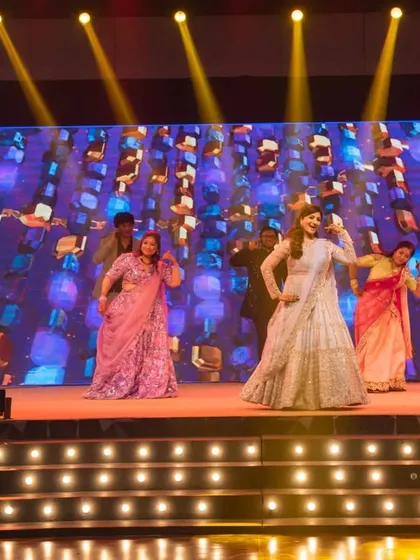 A high-energy dance performance on a professionally lit stage. We coordinate with choreographers and technical teams to produce spectacular sangeet shows.