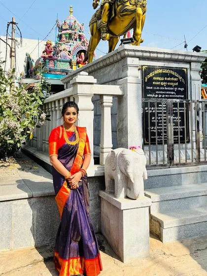 A full-length photo of Pooja at the temple, her saree a perfect blend of tradition and grandeur.