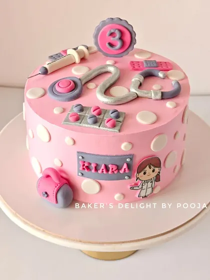 A cake for a future doctor! This fun, pink design for a three-year-old is decorated with a complete toy doctor set made from fondant, including a stethoscope, syringe, and bandages.