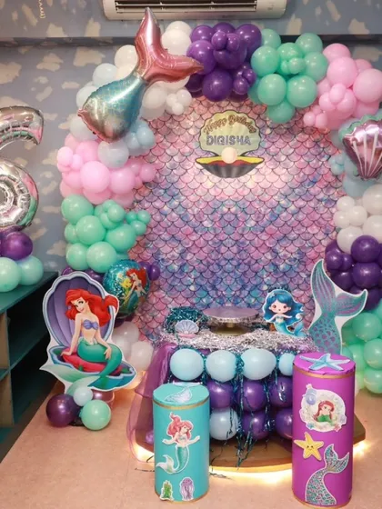 I believe in making dreams come true with magical themed parties. This stunning mermaid birthday setup, complete with an iridescent backdrop and under-the-sea balloon decor, shows how I transform my space into a fairy tale world for your child's special day.