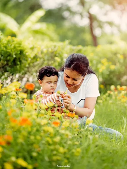 A mother and her young child share a quiet moment of discovery among wildflowers. Our outdoor sessions are perfect for capturing these gentle, natural interactions that show the beautiful bond between parent and child.