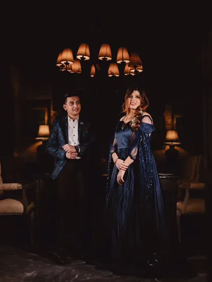 My personal favorite, the navy blue infinity gown. It features a detachable sequin trail and delicate feather details on the sleeves for a touch of glamour.