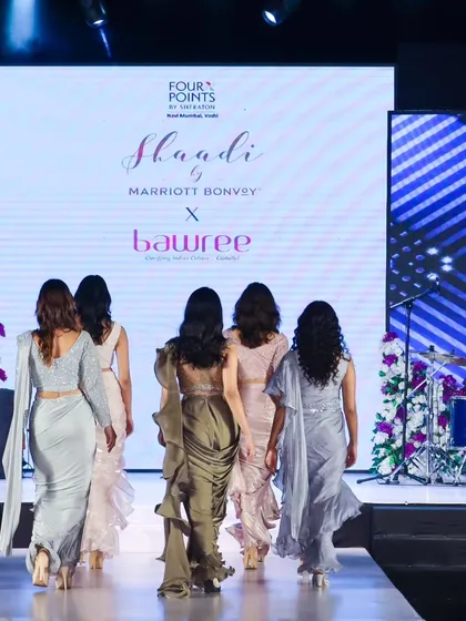 Models walking the finale for a 'Shaadi by Marriott Bonvoy' event, showcasing a collection of modern sarees. This back-facing shot emphasizes the drape and silhouette of the garments.