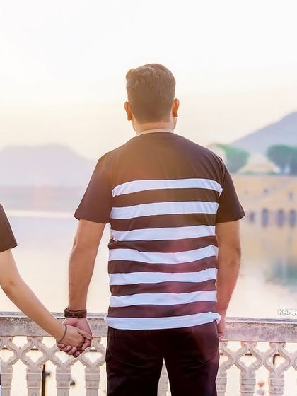 A forward-looking pose, holding hands while gazing at the Jal Mahal. This shot symbolizes the couple looking towards their future together.