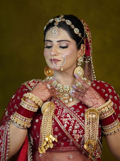 A series of portraits showcasing a bride in a traditional red lehenga. The focus is on the detailed craftsmanship of the outfit and the perfectly matched kundan jewellery.