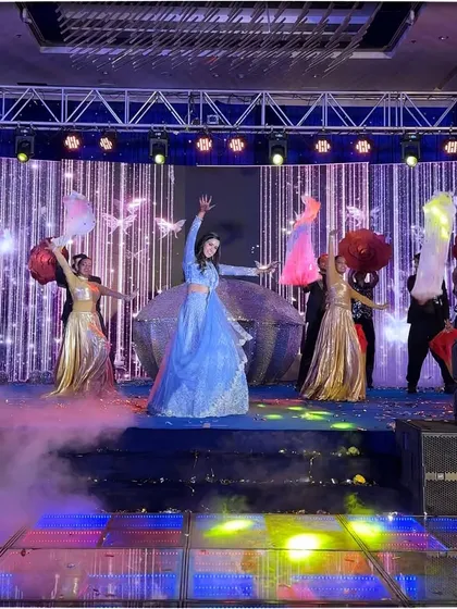 The bride's talent and charm shone brightly in this performance, surrounded by dancers and smoke on a vibrant stage.