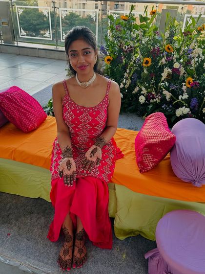 A lovely client at her mehndi ceremony, showing her minimalist paisley designs on her hands and feet.