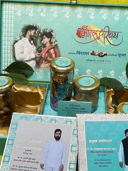 An invitation can be so much more than a card; it can be a personalized gift. This light green hamper box features the couple's photo inside the lid, along with a curated selection of dry fruits and chocolates, making it a truly special token of gratitude for your guests.