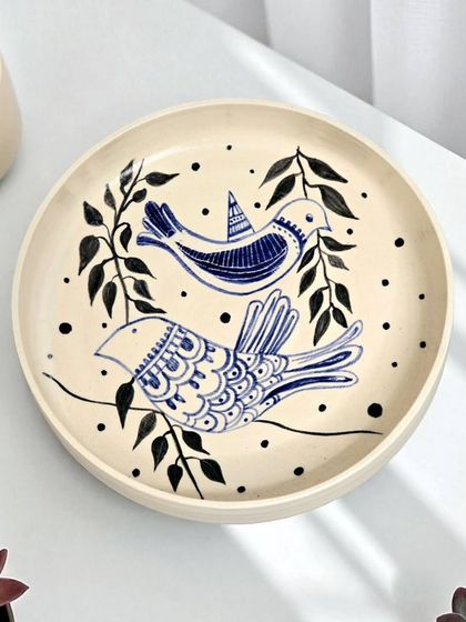 This hand-painted ceramic plate features a delicate bird motif, symbolizing freedom and a connection to nature. Meticulously wheel-thrown, it serves as a gentle reminder to pause and embrace the present moment.