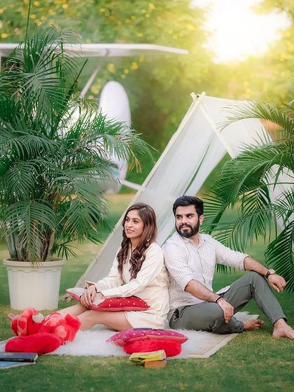 A beautifully composed wide shot of the picnic setup, featuring the couple, a vintage bicycle, and the airplane prop. This highlights the variety of props available for your outdoor photoshoot.