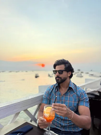 Enjoying a sunset drink, our client looks relaxed and stylish in the blue check shirt, making it the perfect piece for vacation evenings.