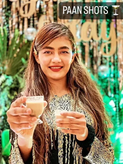 A guest enjoying our signature Paan Shots, a creative and refreshing mouth freshener to end the meal.
