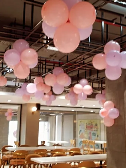Simple and sweet balloon bunches hanging from the ceiling. This kind of decor is perfect for a baby girl's party, adding a touch of color and fun to the entire space.