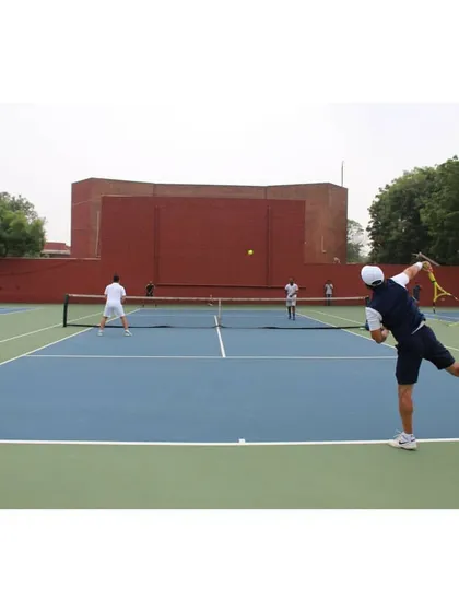 A player executes a powerful serve during a training match at our academy. This shot captures the intensity and focus we instill in our players, preparing them for the pressures of competitive play through realistic match simulations on our professional-grade courts.