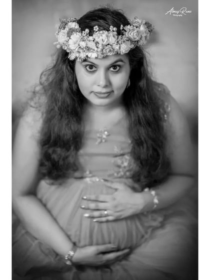 A powerful black and white close-up. By removing color, this image draws all the attention to the mother's expressive eyes and the gentle way she holds her baby bump.