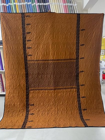 The orange side of the reversible saree quilt, showcasing a completely different color palette and pattern.