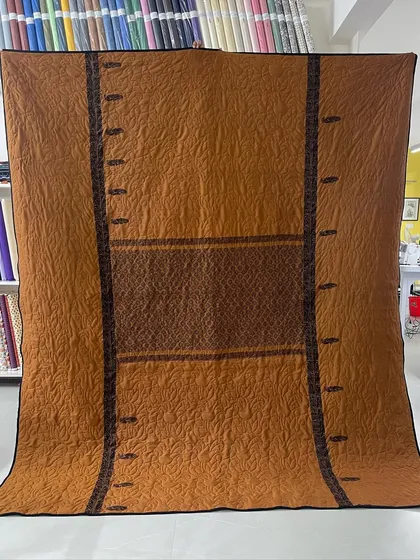 The orange side of the reversible saree quilt, showcasing a completely different color palette and pattern.