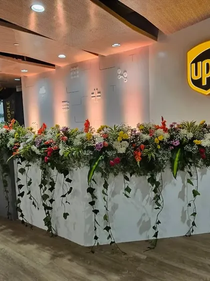 I transform standard office areas into vibrant, welcoming spaces. This lush floral arrangement on the UPS reception desk adds a touch of nature and sophistication for your launch event.