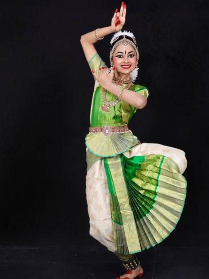 Manasvi looks like a joyful Krishna, complete with a flute and peacock feather, for her Arangetram photoshoot.