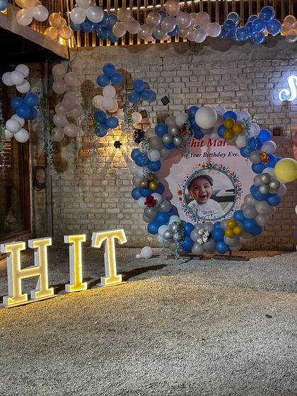I love hosting first birthday parties. Here’s a complete setup with large light-up letters spelling the birthday boy's name, a custom photo backdrop, and a balloon arch.
