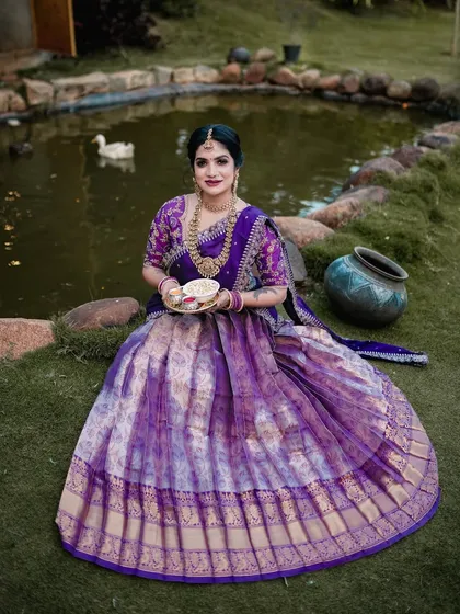 A serene portrait of a woman in a beautiful purple half-saree, taken by a pond. This was part of a special shoot for the Sankranti festival.