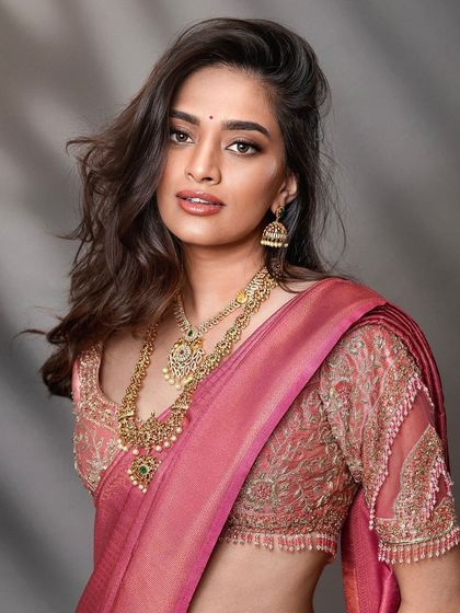 A modern South Indian bridal look, focusing on the intricate blouse embroidery and layered necklaces. The soft, diffused lighting creates a flattering portrait that is both contemporary and timeless.