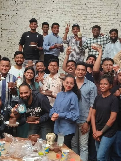 The whole crew. A group photo of the enthusiastic participants from our corporate workshop with Don Julio, all proudly displaying the ceramic pieces they created. It was a fantastic day of team building and creativity.