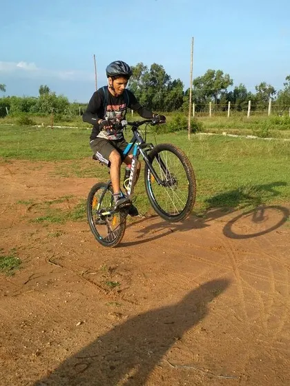 A rider showing off some skills with a wheelie on a dirt track. Our off-road rides are a great place to have fun and test your bike handling.