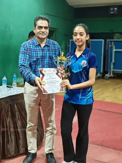 Hrithika Madhur receives her trophy after winning first place in the women's category at the 2nd District Ranking tournament.