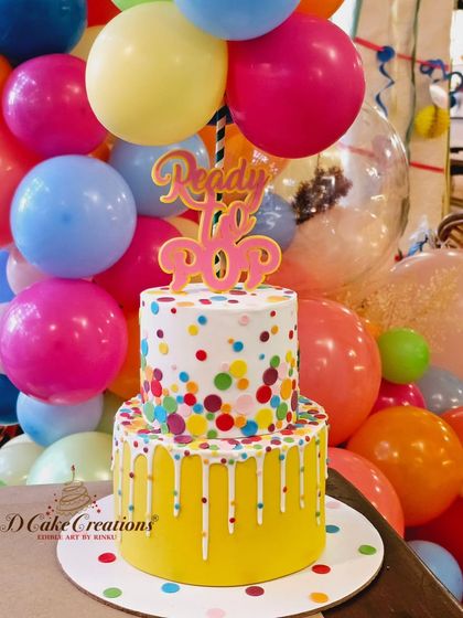 The confetti and balloon cake in its party setting, surrounded by vibrant decorations for Rochelle and Keith's baby shower.