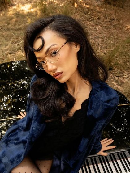 A close-up portrait for John Jacobs, highlighting the delicate frames and the model's expression.