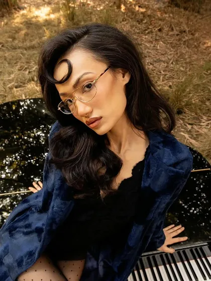 A close-up portrait for John Jacobs, highlighting the delicate frames and the model's expression.