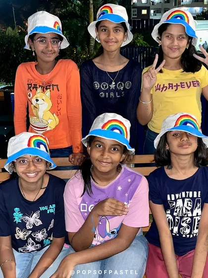 A party of best friends rocking their custom-painted rainbow bucket hats. Our wearable art parties are a huge hit, letting kids design something they can show off long after the celebration ends. It's creativity you can wear.