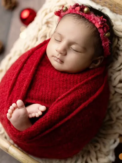 An adorable shot of a baby's tiny feet peeking out of a red swaddle in our Christmas-themed sleigh.