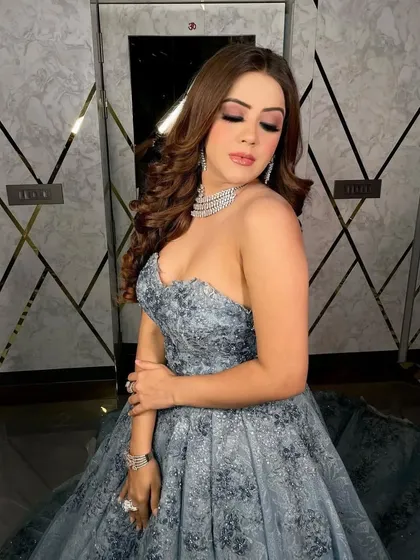 A client seated in a strapless grey ball gown with intricate dark grey embroidery. This is a sophisticated and timeless choice for any formal event.