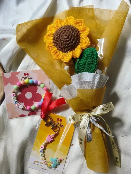 We also offer gift sets. This one includes a single sunflower bouquet paired with a personalized name bracelet and a floral keychain.