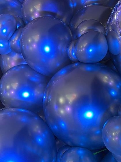 Another artistic close-up of the chrome balloons, highlighting their unique shine and the blue lighting.