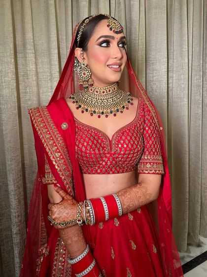 This look is for the bride who wants a classic red outfit with a modern makeup twist. The shimmery bronze eyes and flawless skin create a stunning contrast that is both bold and beautiful.