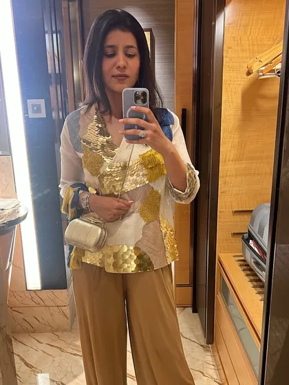 A mirror selfie showing off a dressy top with gold sequin details. This is a great example of an indo-western piece that can be dressed up for a party or a sangeet.
