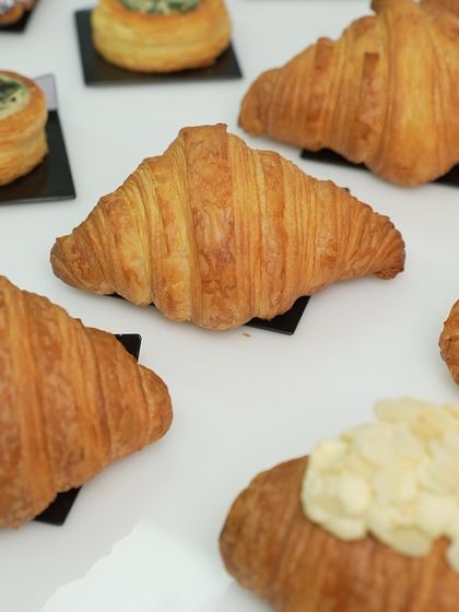 A beautiful, golden-brown croissant, perfectly shaped and baked. This image showcases the classic viennoiserie skills taught in our professional diploma program.