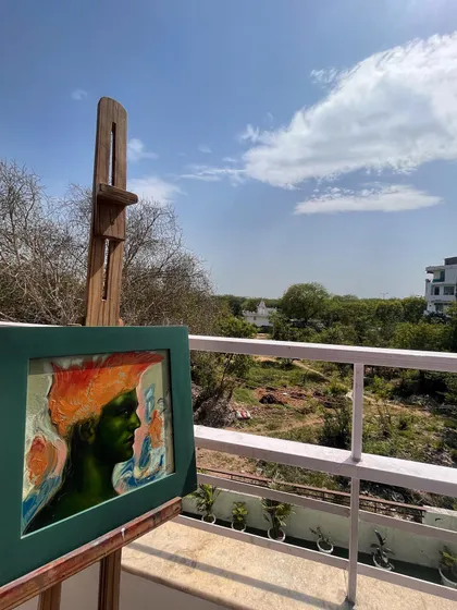 "Spring Vibes 2," a 12x12 inch oil on canvas, drying on the easel on my studio balcony. The natural light helps me see the true colors as I work.