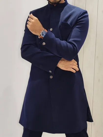 The Nawabi style offers a sleek and royal look. This custom-fit navy blue Nawabi sherwani is perfect for any wedding function, providing a sharp and distinguished appearance.