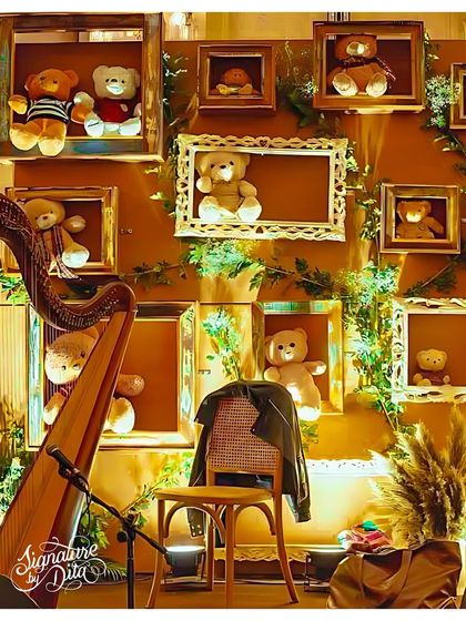 A creative photo wall featuring framed teddy bears, with a harp in the foreground to provide live, elegant music, enhancing the sophisticated atmosphere.